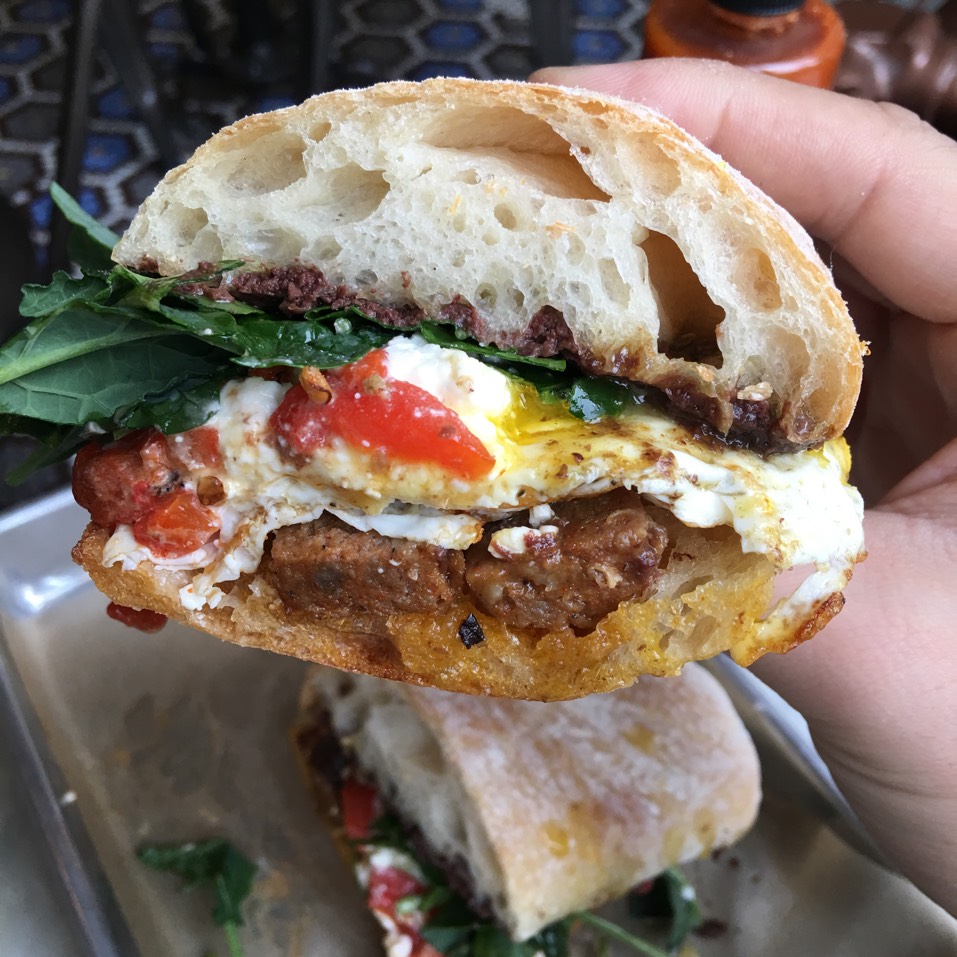 Greeky Roman Sandwich (Lamb sausage, feta, baby kale, roasted peppers & olive tapenade, pugliese roll) on #foodmento http://foodmento.com/dish/34183